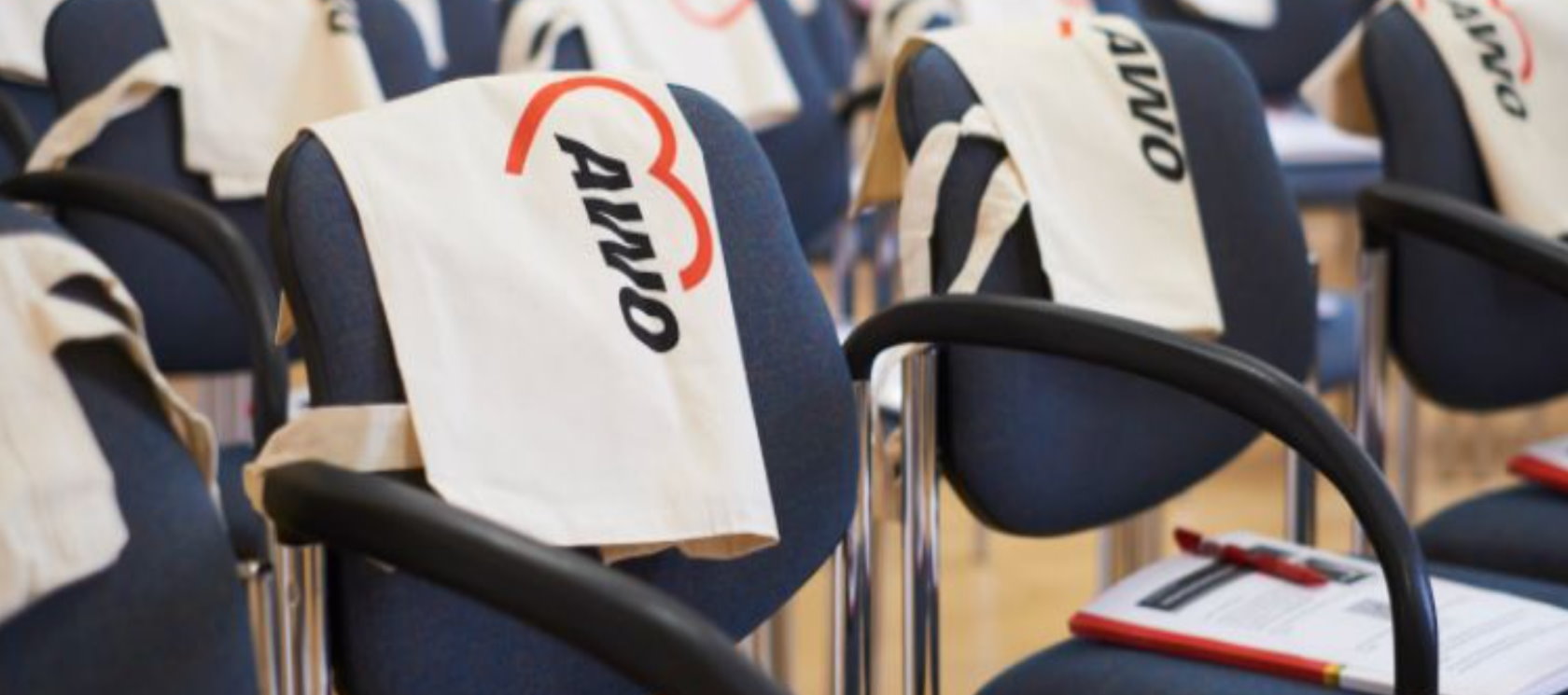 Das Bild zeigt Stuhlreihen mit weien Jutetaschen mit AWO Logo.